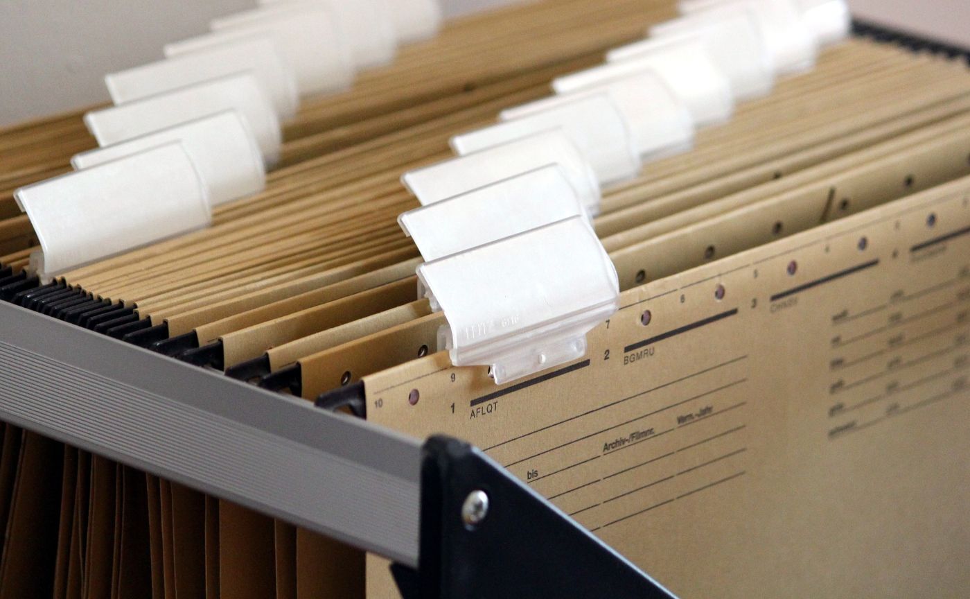 A file cabinet filled with folders and papers, representing organization and document storage.
